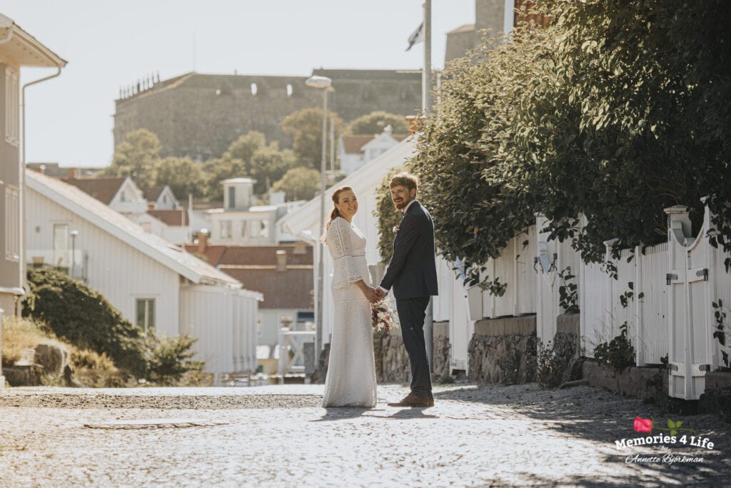 brudparet står på kullerstensgatorna i marstrand