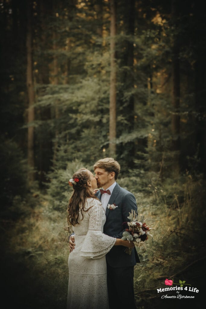 brudparet kysser varandra i skogen