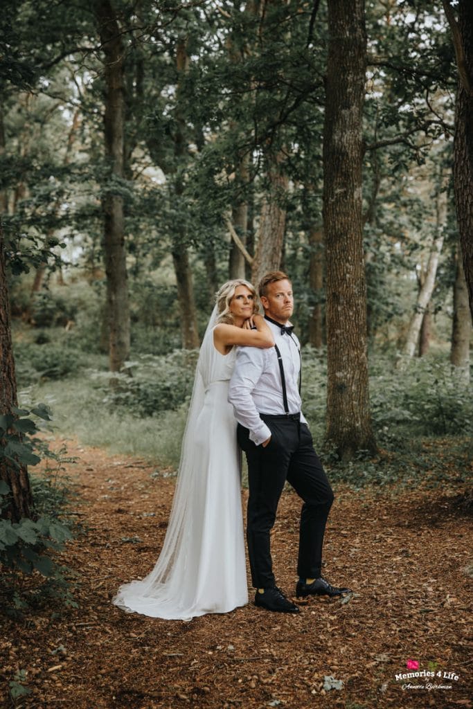 Bröllopsbild av ett par i skogen, perfekt för bröllopsfotografering 2023.